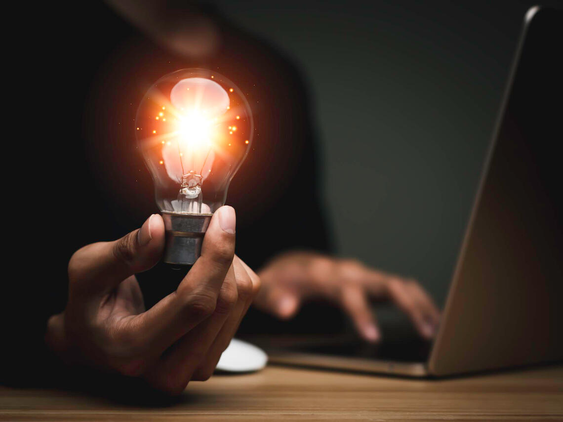 business man holding lightbulb